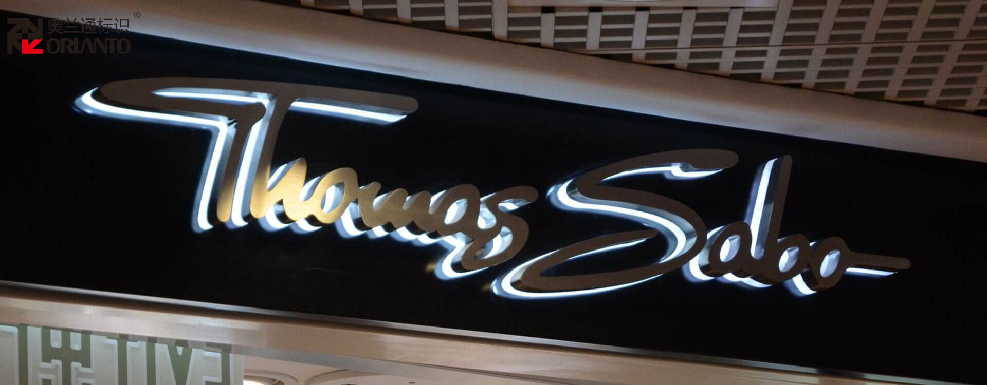 5581787644608341.jpg Metal luminous letter installed on shopping mall storefront facade with warm ambient lighting